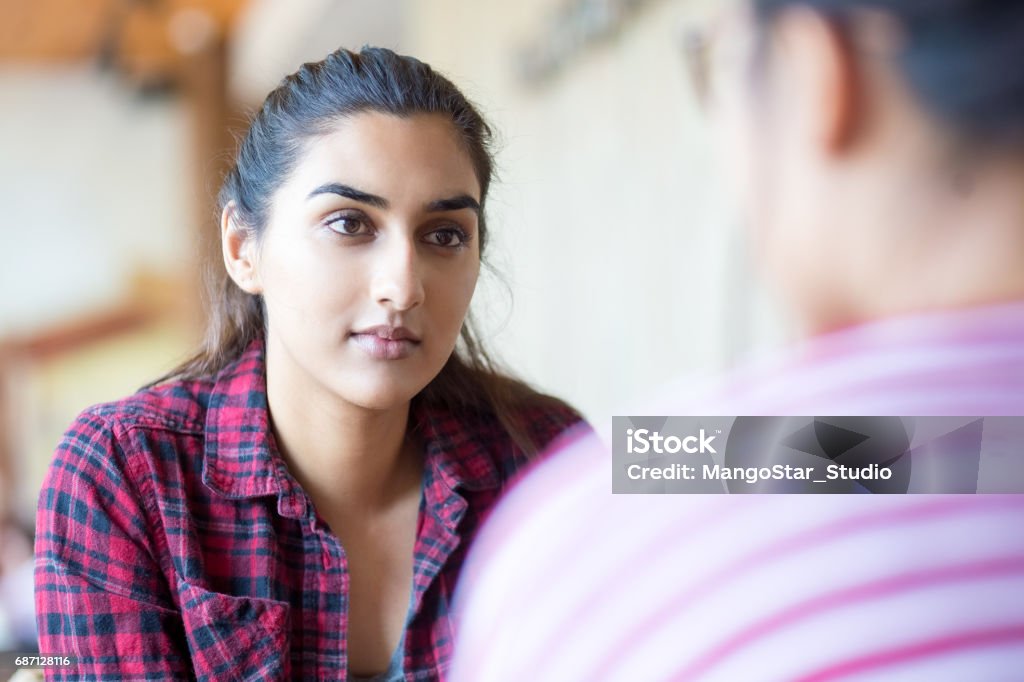 Mujer India concentrada hablando con amigo - Foto de stock de Escuchar libre de derechos