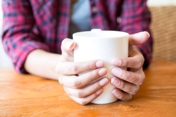istock Woman holding hot mug to warm up hands 687128272