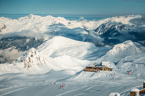 View from the top of a mountain, with skiers and restorant in a distance, France, La Plagne