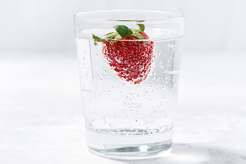 glass of carbonated water with fresh strawberries, horizontal