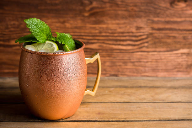 Cold Moscow Mule cocktail in copper mug on the rustic background. Shallow depth of field.