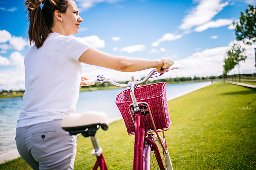 Woman pushing pink bike
