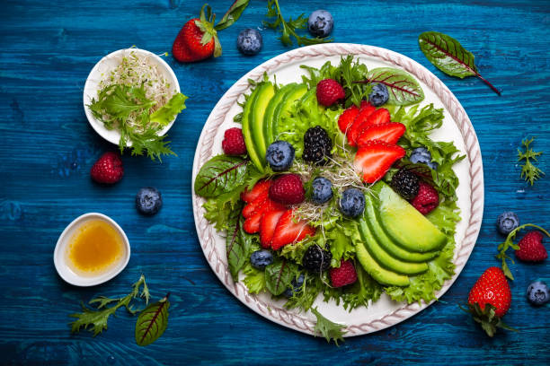 salad and appetizer Mixed salad leaves with berries, avocado and honey-mustard dressing mustard fruits stock pictures, royalty-free photos & images