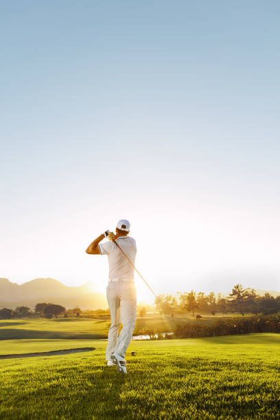 junger mann spielt golf an einem sonnigen tag - playing golf fotos stock-fotos und bilder