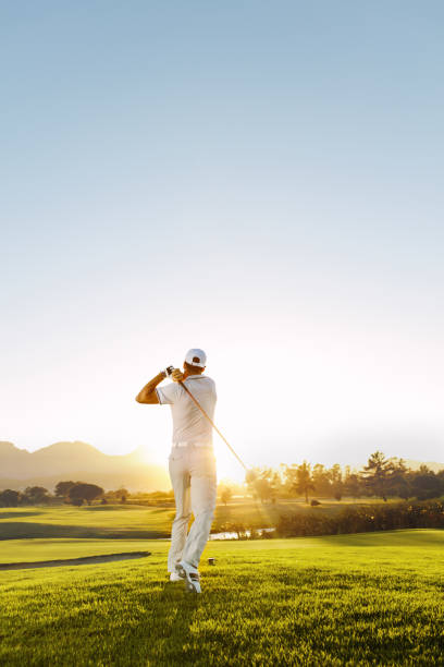 joven jugando al golf en un día soleado - golf fotografías e imágenes de stock