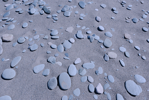 Flat Skipping Stones rest on Sand