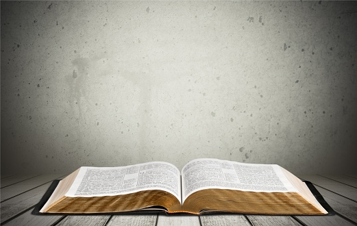 Open book on old wooden table.