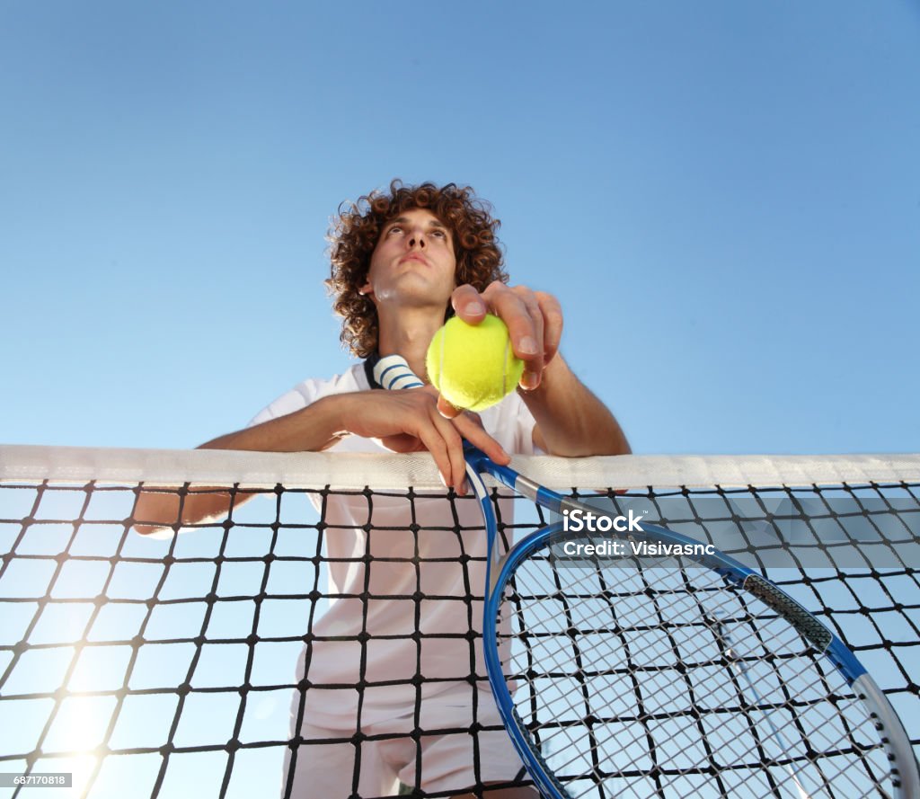 tennis player with racket and ball standing in front of the net Active Lifestyle Stock Photo