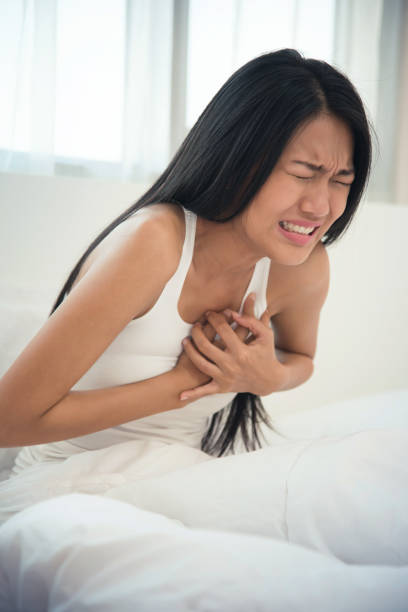 istock Asian woman having heart attack on her bed. copy space. 687174842