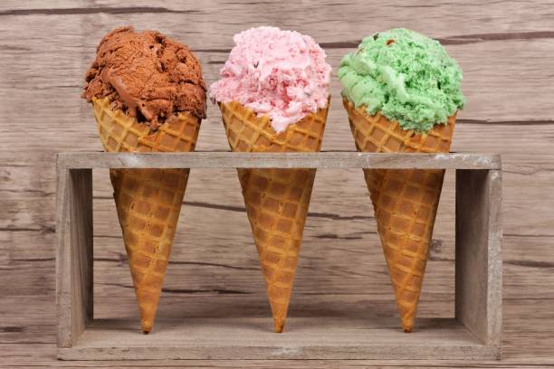 istock Three waffle cones of ice cream in rustic holder over wood 687180700