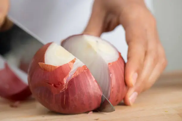 Woman chopping onion, close up.