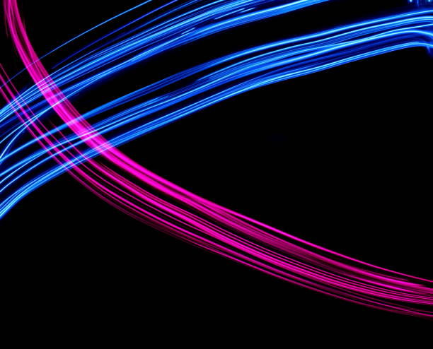 istock Blue and Pink Light Painting Photography, smooth line patterns against a black background 687181214