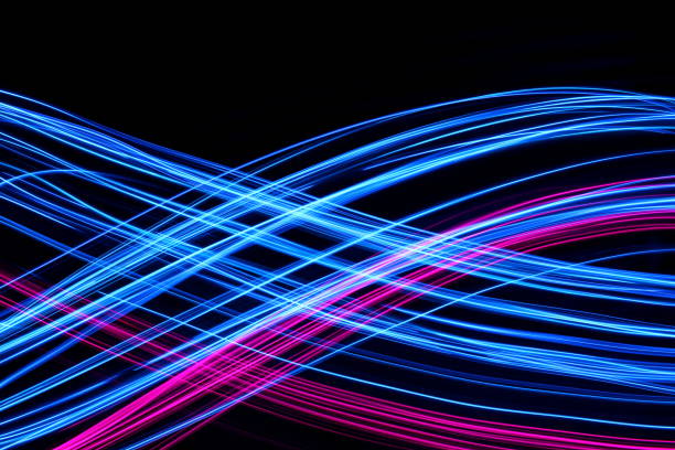 istock Blue and Pink Light Painting Photography, smooth line patterns against a black background 687181260