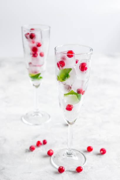 istock Ice cubes with berries and mint in glasses for summer drink white background 687210552