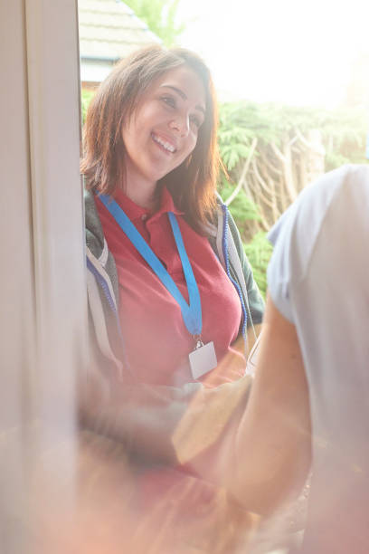 istock smiling charity worker at the front door 687212958