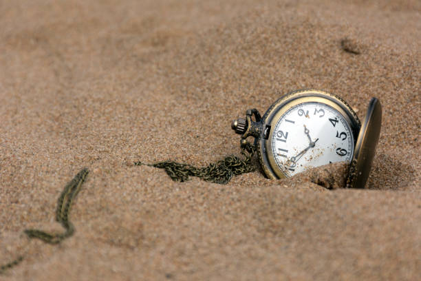 istock round pocket watch on a chain in the sand ,time, dial 687213654