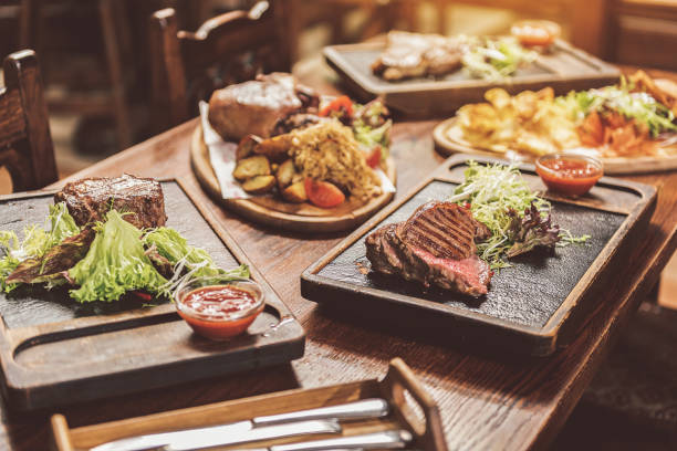 Tasty mix. Close up of grilled meat meals are on wooden table. Focus on juicy medallion and appetizing steak