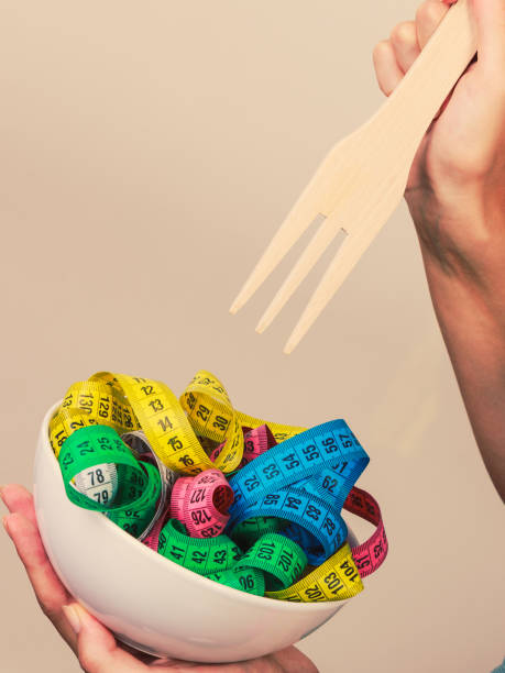 istock Diet. human hand and measuring tapes in bowl 687232208