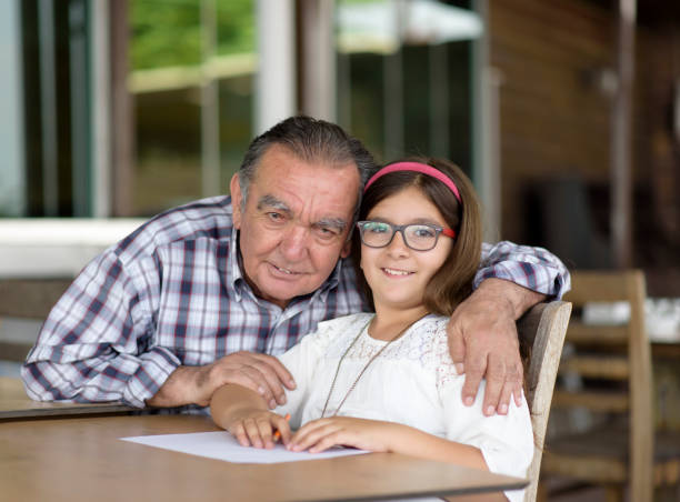 niña con su abuelo - whispering grandparent child grandfather fotografías e imágenes de stock