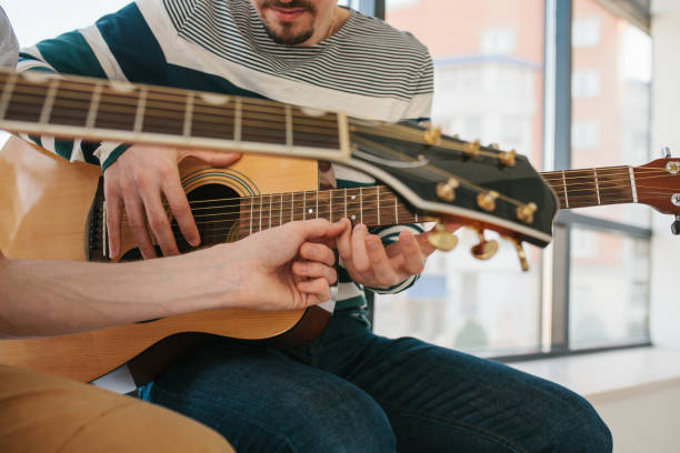 istock Learning to play the guitar. Music education and extracurricular lessons. 687235492