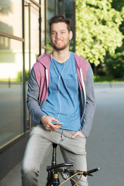 istock Young man on bike using smartphone 687236550