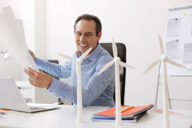 istock Positive senior engineer designing plan of wind turbine construction 687239660