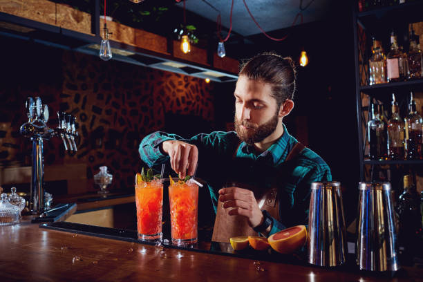 istock Bartender with a beard makes a cocktail behind counter in the ba 687240064