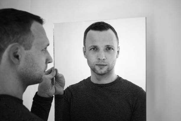 istock Black and white portrait of young man with mirror 687250034