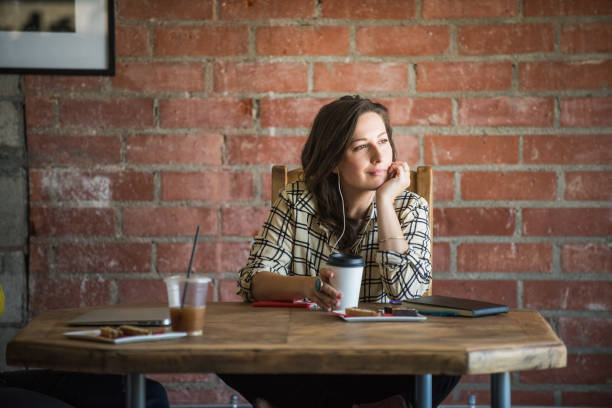Young Woman Listening to a Podcast in a Cafe stock photo