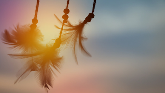 Dream catcher silhouette in the rising sun with blurred focus for background