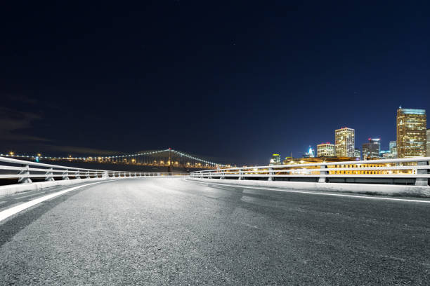 istock empty road with modern city at night 687344386