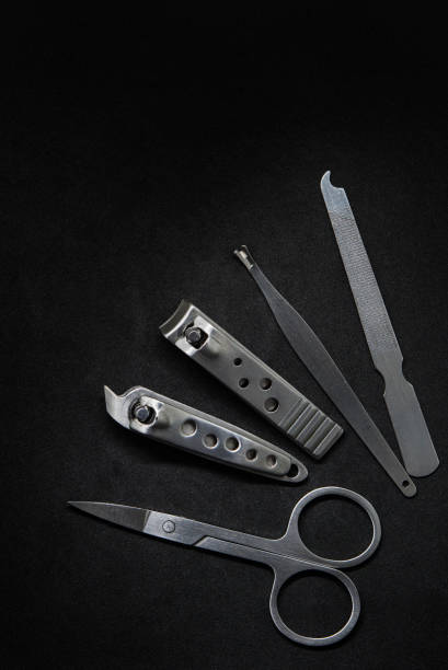 Stainless steel nail clippers on black backdrop stock photo