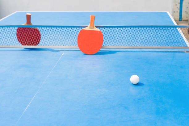 istock pingpong rackets and ball and net on a blue pingpong table 687356170