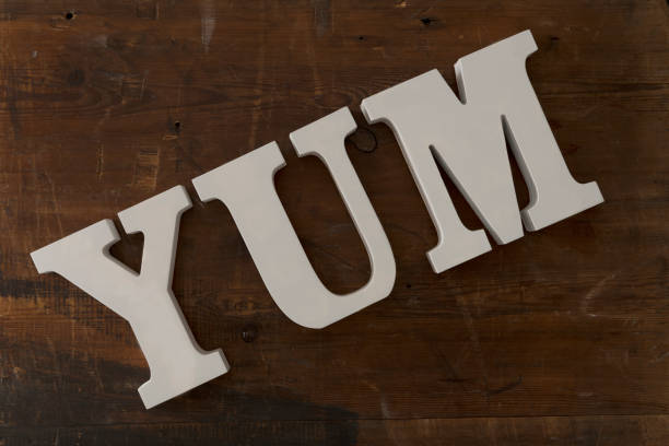 istock 3D Letters Spelling YUM Over Wooden Background 687356884