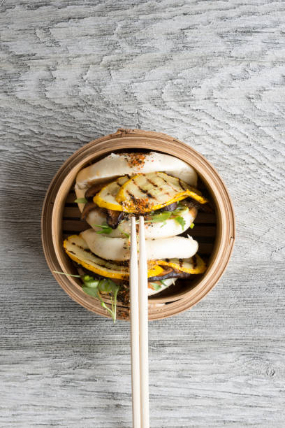 istock Chopsticks on Vegetarian Chinese Steamed Buns in Bamboo Steamer 687359656