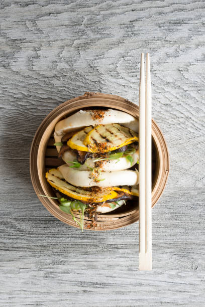 istock Overhead of Chopsticks on Steamed Buns in Bamboo Steamer 687359706