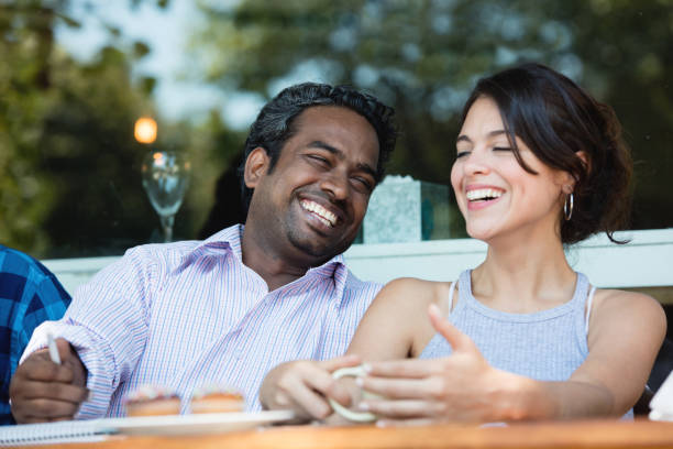 istock Multi-ethnic couple laughing while having a cup of coffee 687359932