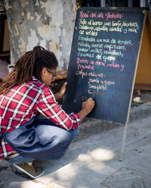 istock Man working at a restaurant writing the menu on a chalkboard 687360016