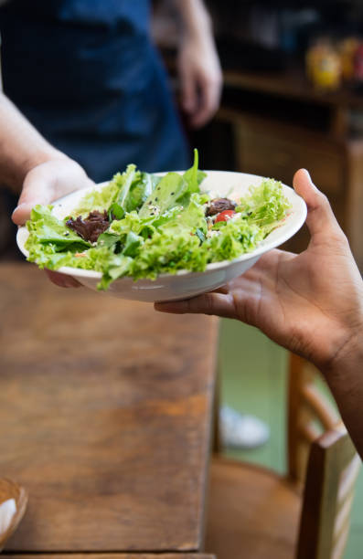istock Close-up on a waiter serving food at a restaurant 687360048