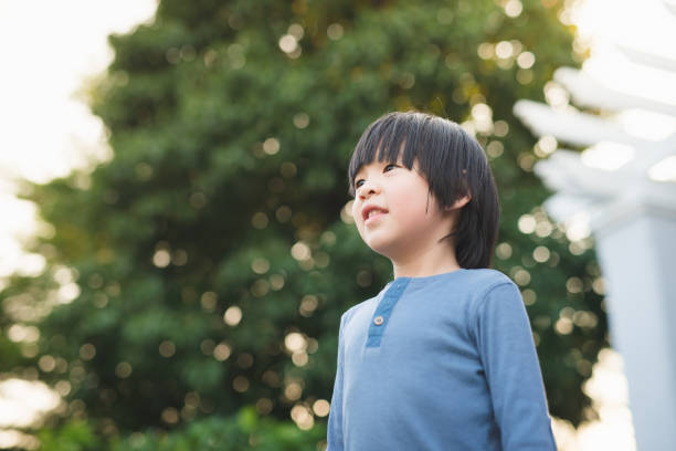 istock Asian child looking up outdoors 687363730