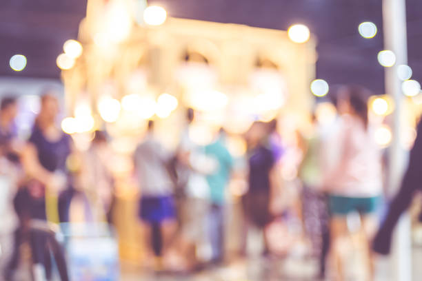 Blurred background: crowd of people in expo fair with bokeh light ,Vintage filter
