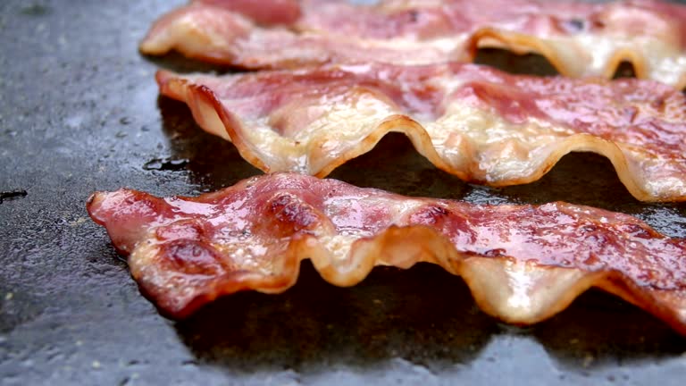 Close-up of a slice of bacon fried on grill