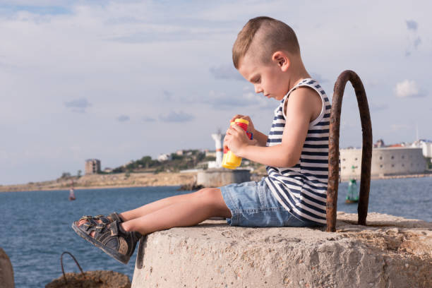 istock curious little boy with binoculars on the sea background 687389068