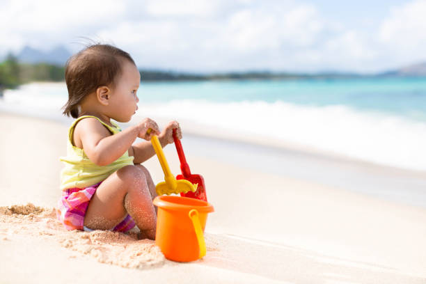 istock Child playing on sandy beach with a bucket and shovel 687401858