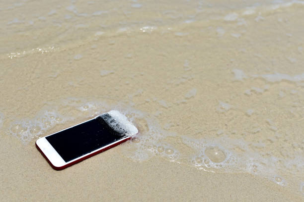verloren phone.phone viel verdwijnen op strand voor achtergrond - lost phone stockfoto's en -beelden