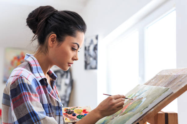 istock Side view of female artists drawning in workshop 687407192