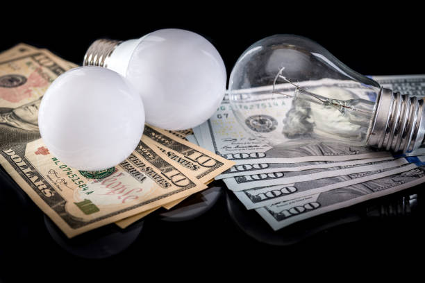 istock light bulb with dollar isolated on black. close up 687410384