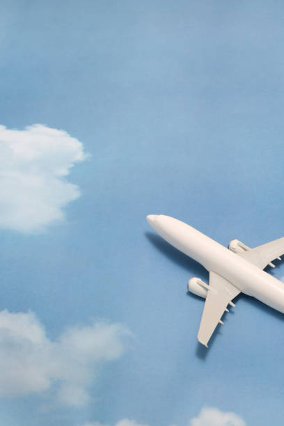 istock Miniature toy airplane on blue sky with clouds. Trip by airplane. 687422356