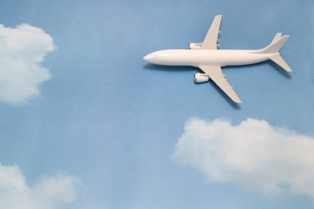 istock Miniature toy airplane on blue sky with clouds. Trip by airplane. 687422362