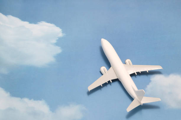 istock Miniature toy airplane on blue sky with clouds. Trip by airplane. 687422376